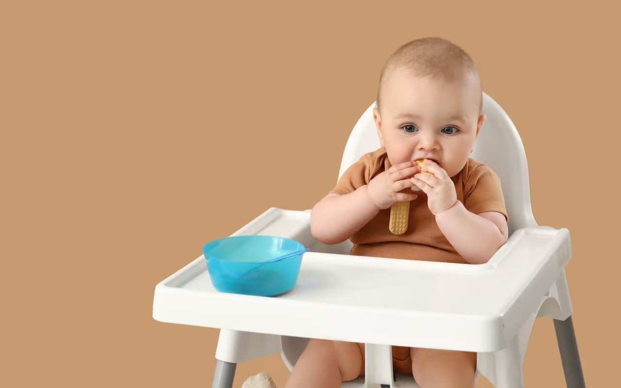 Bébé de 6 mois assis sur un tapis d'éveil, un jouet dans la main