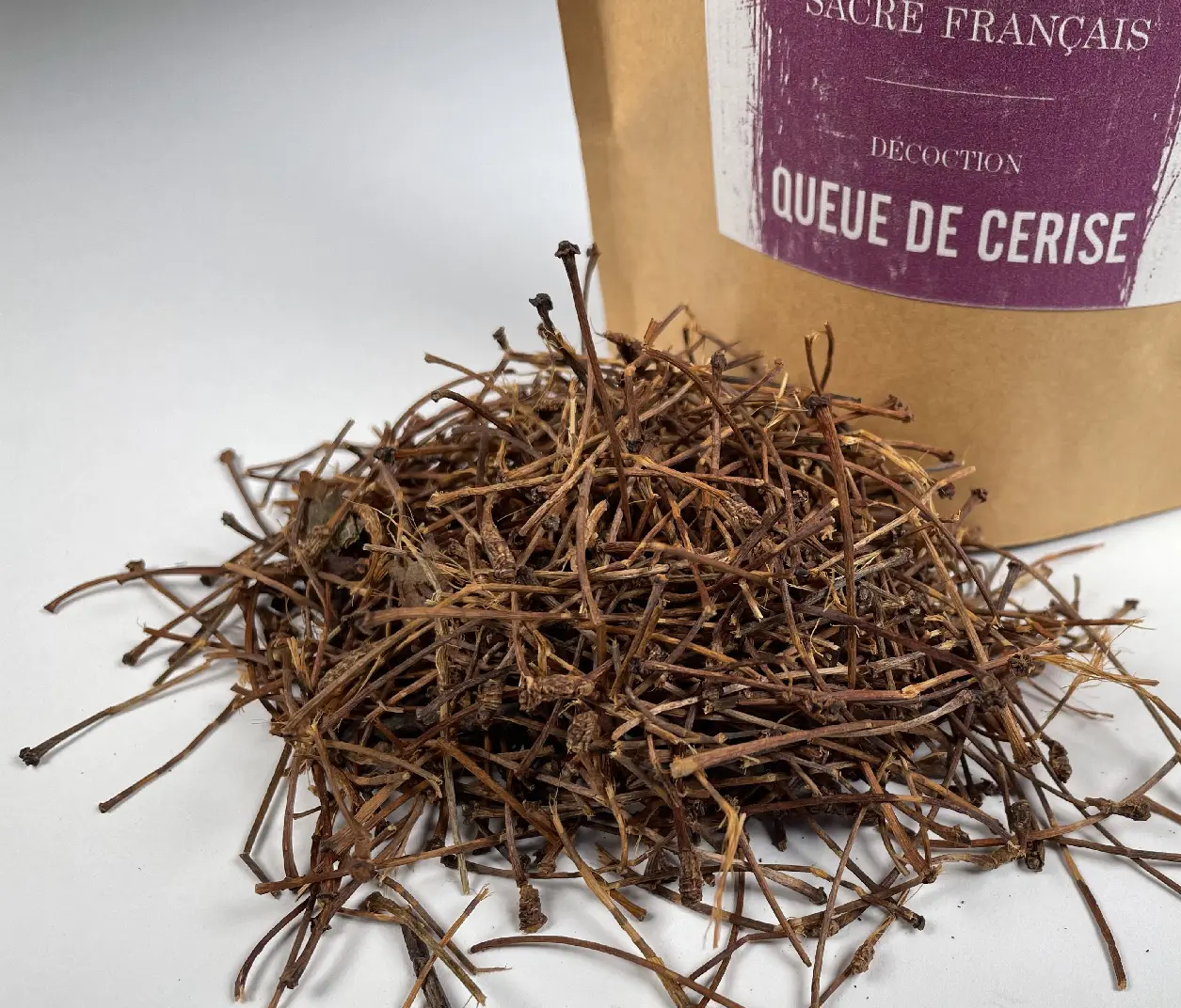 Tasses d'infusion de queues de cerise séchées posées sur une table en bois